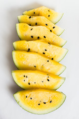 cut a slices of ripe yellow melon on a white background