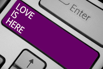 Text sign showing Love Is Here. Conceptual photo Romantic feeling Lovely emotion Positive Expression Care Joy Keyboard purple key Intention create computer computing reflection document