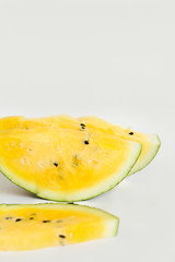 cut a slices of ripe yellow melon on a white background