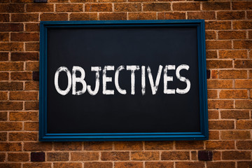 Conceptual hand writing showing Objectives. Business photo showcasing Goals planned to be achieved Desired targets Company missions Framed hang black board study class brick wall background