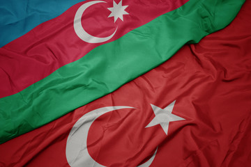 waving colorful flag of turkey and national flag of azerbaijan.