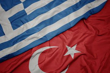 waving colorful flag of turkey and national flag of greece.