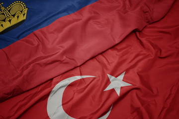 waving colorful flag of turkey and national flag of liechtenstein.