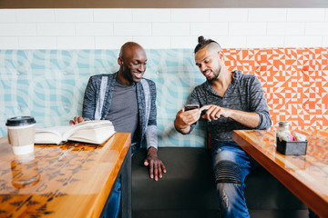 Two people browsing mobile phone and smiling