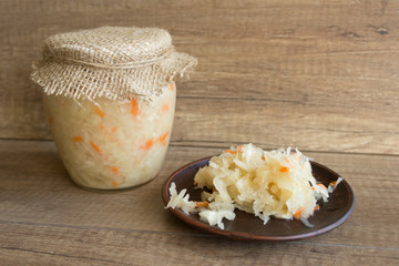Sauerkraut in glass jar, marinated cabbage, carrot. Probiotic and fermented food. Pickles. Canned vegetarian food concept.
