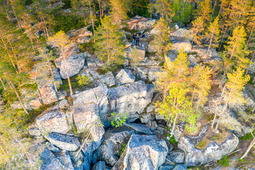 Drone photo of Northern Scandinavian forest in rocky mountains, big stones, yellow green trees at the end of summer - beginning of autumn. Gorge pass