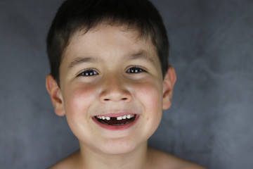 ni&ntilde;o feliz que ha perdido un diente de leche