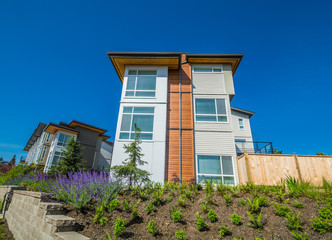 Brand new townhouse building on the hill with landscaped slope on sunny day