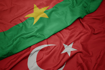 waving colorful flag of turkey and national flag of burkina faso.