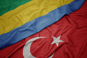waving colorful flag of turkey and national flag of gabon.