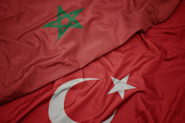 waving colorful flag of turkey and national flag of morocco.