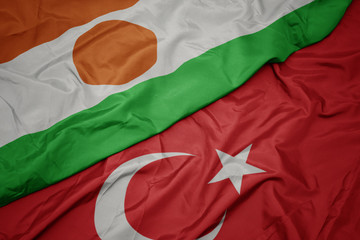 waving colorful flag of turkey and national flag of niger.