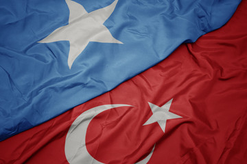 waving colorful flag of turkey and national flag of somalia.