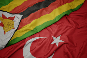 waving colorful flag of turkey and national flag of zimbabwe.