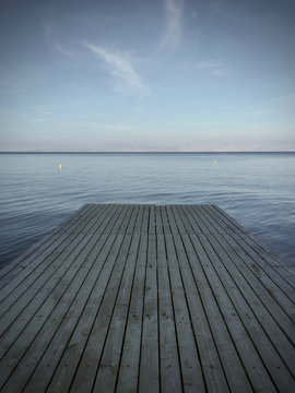 Wooden jetty in the sea with blue sky