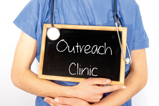 Doctor Shows Information On Blackboard: Outreach Clinic.  Medical Concept.