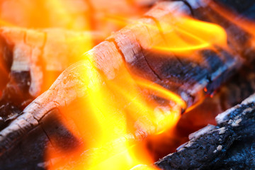 Beautiful color of burning red coals and black charred wood. Orange hot coals in the Russian stove. Red burning coals as a texture for design.
