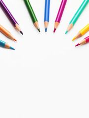 Colorful watercolor pencils on white background. School supplies with round copy space. Kid's stationery. Back to school circle backdrop.