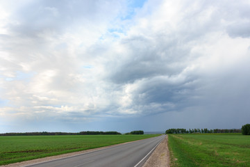 The road in the Russian village with a cloudy sky before a thunderstorm.