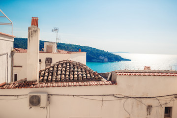 The narrow streets of the island with blue balconies, stairs and flowers.