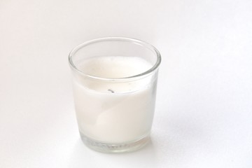 Used white candle light in a glass on white background with softly style 