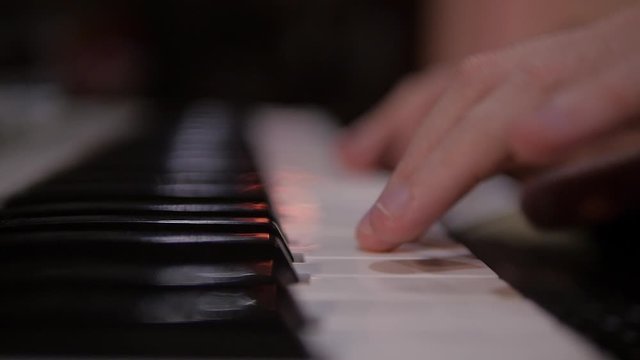 Musician's hands are playing the keaboard at the studio. Close up.