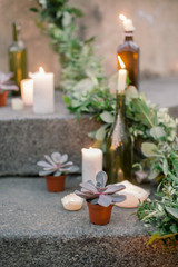 Obraz na płótnie Canvas Wedding ceremony decor, decorated stone stairs with white burning candles and fresh greenery, flowers and succulents