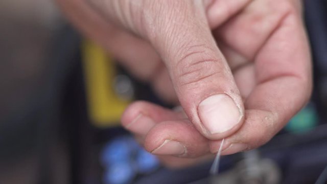 Close up shot of a technician splicing an optical fiber cable using tweezers