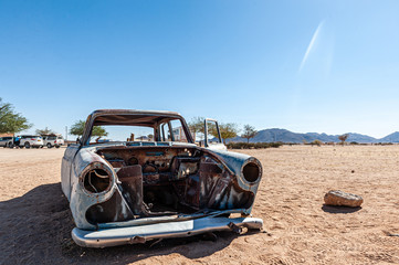 Fototapeta na wymiar Wrecks of historic cars line the road in the town of Solitaire in the Khomas Region of Namibia.