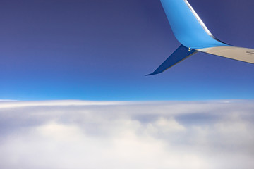 Continuous cloud cover and wing tip. Clouds from the porthole. The view from the plane. 