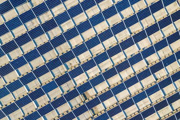 Top view of blue shiny solar photo voltaic panels system producing renewable clean energy abstract background.