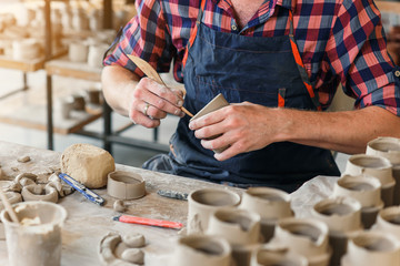 Focused male potter making something from clay.