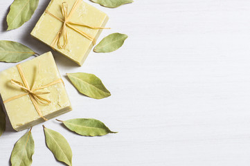 Organic natural handmade bay laurel soap with olive oil and leaves on white rustic backdrop, daphne...