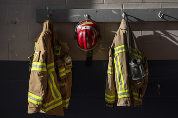 Firefighter protection gear hanging on fire station wall
