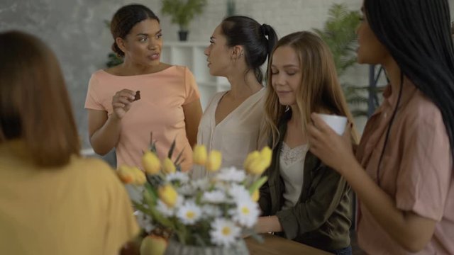 5 mixed race girlfriends drink tea / coffee in the kitchen. women having fun and chatting 4K