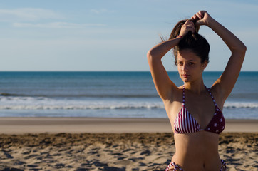 Beautiful girl in a bikini on the sand at the beach