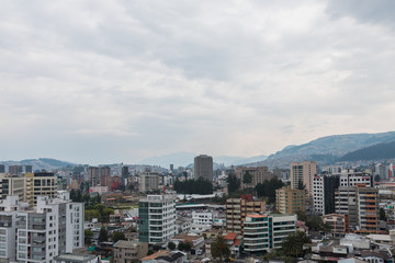 Atardecer de ciudad sudamerica en Quito Ecuador con edificios y montañas de fondo