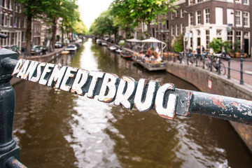 View from Dansemertbrug bridge in Amsterdam with canal and buildings in the background