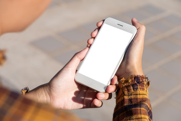 Woman hand holding and using smart phone with blank screen at outdoor background