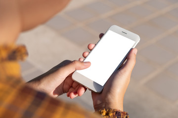 Woman hand holding and using smart phone with blank screen at outdoor background