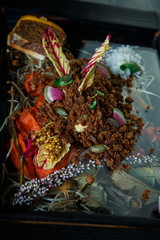 vertical view closeup on trendy dish of crumbled bark bread and sliced radish
