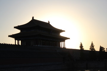 the sunset behind a temple in the Forbidden City in Beijing China