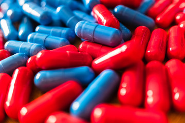 Detail of a handful of mixed red and blue pills.