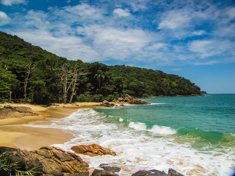 Praia do Cedro in Ubatuba, Brazil, with crystal-clear water, stunning rocks, and preserved nature, captured on a sunny day, showcasing the beauty of a remote, tranquil beach.
