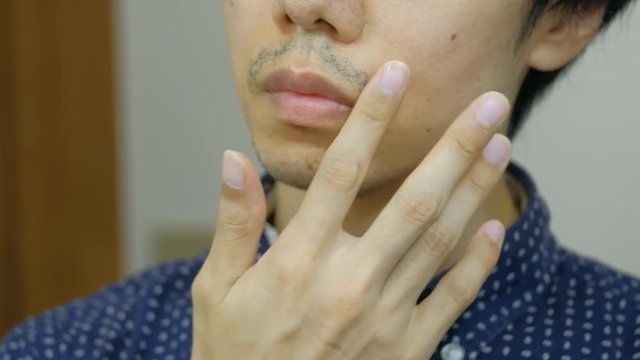 無精ひげを触る日本人男性