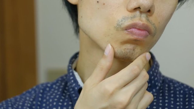 無精ひげを触る日本人男性