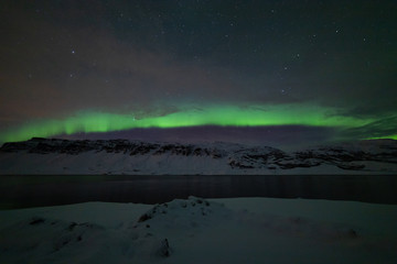 Fototapeta na wymiar Aurora arching over the fjord