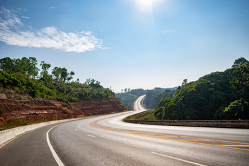 Landscape of beautiful road with forest on the side way and blue sky