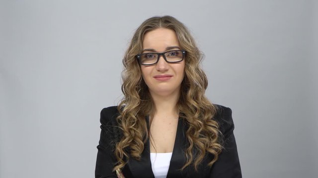 Bussines woman stands worrying in expectation at grey background