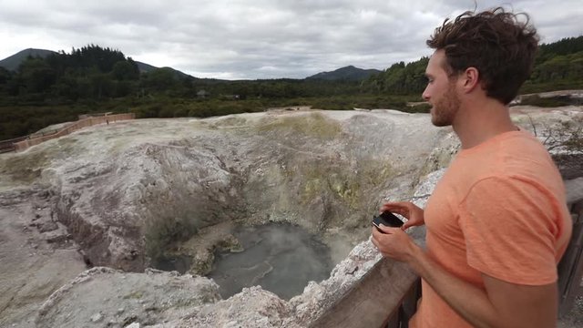 New Zealand travel tourist taking phone picture of famous attraction, Waiotapu. Active geothermal area, Okataina Volcanic Centre, Reporoa, in Taupo Volcanic Zone, Rotorua, north island.